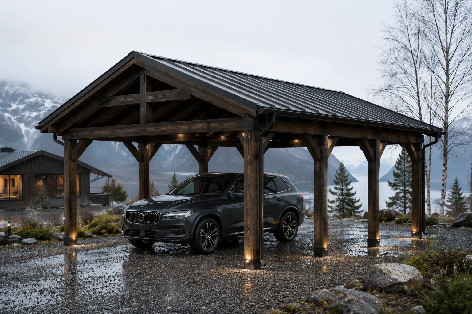Frittstående carport i mørkbeiset tre med saltak og stålplatetak, bil parkert under, foran fjord og fjell i Norge